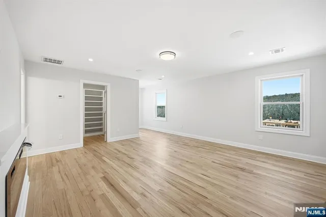 an empty room with wooden floor and window