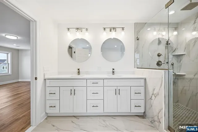 a bathroom with a double vanity sink mirror and shower