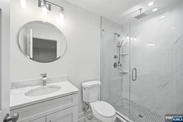 a bathroom with a sink a toilet and shower