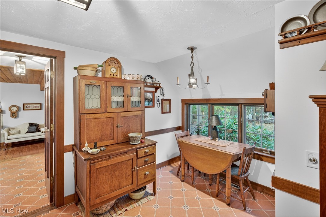 25700 Winona Road Homeworth, OH 44634 - Photo 8 of 49 Breakfast area featuring light tile patterned floors, a chandelier, and a textured ceiling