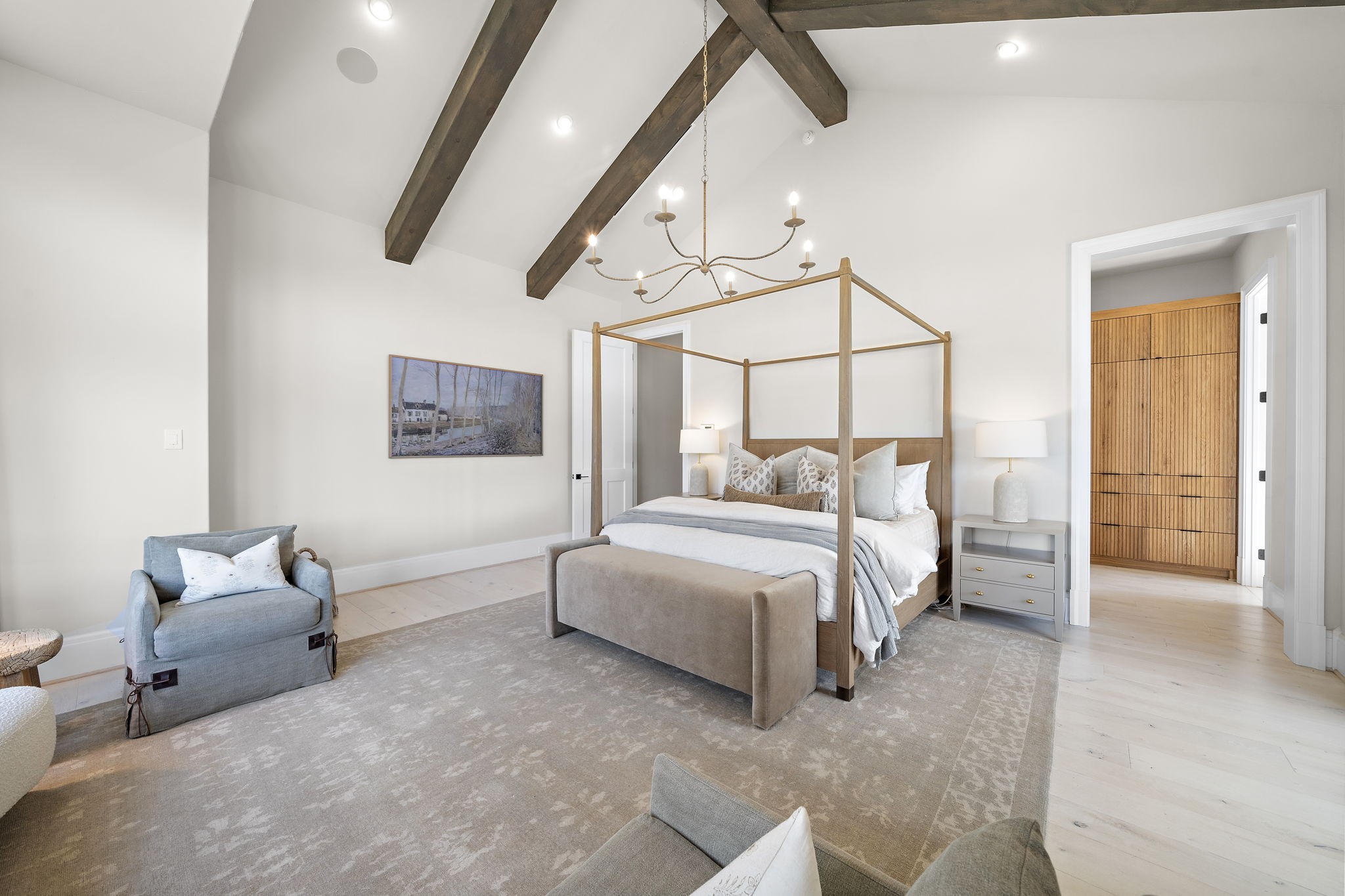 5511 Fulbrook Road Fulshear, TX 77441 - Photo 19 of 50 The primary bedroom is accessed through a private hallway and features spacious bedroom with a seating area, vaulted ceilings, designer chandelier, and accented with wood beams.