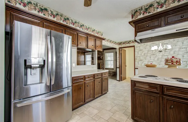 a kitchen with stainless steel appliances granite countertop a refrigerator and a stove