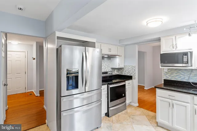 a kitchen with stainless steel appliances granite countertop a refrigerator stove and oven