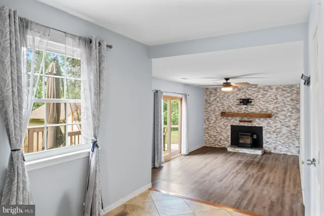 a view of an empty room with window and fire place