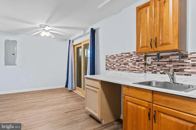 a kitchen with stainless steel appliances granite countertop a sink and a window with wooden floors