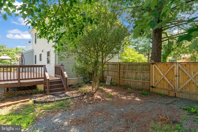 a view of a backyard with a fence and a tree