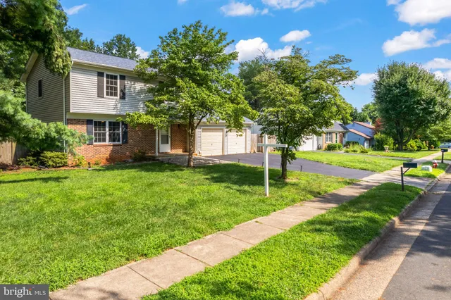 a view of a house with a yard and tree s