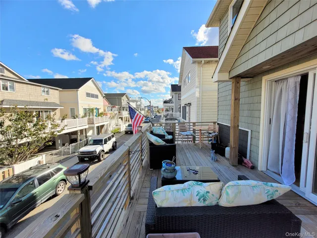 a view of a patio with couches table and chairs with wooden floor