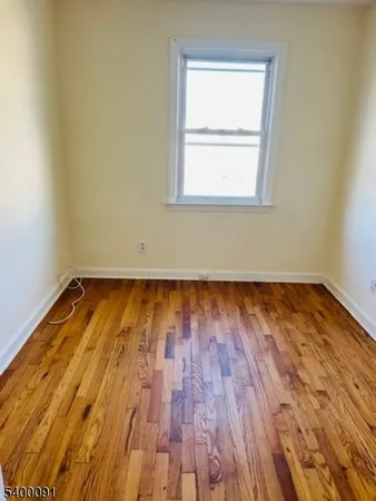 an empty room with wooden floor and a window