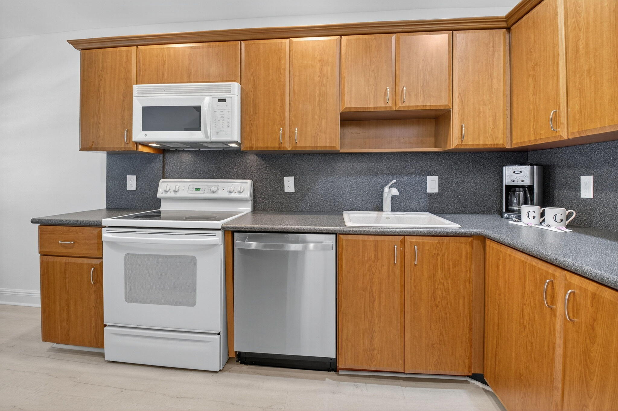 10 Southport Lane, Unit B Boynton Beach, FL 33436 - Photo 25 of 80 a kitchen with stainless steel appliances granite countertop a stove a sink and a microwave
