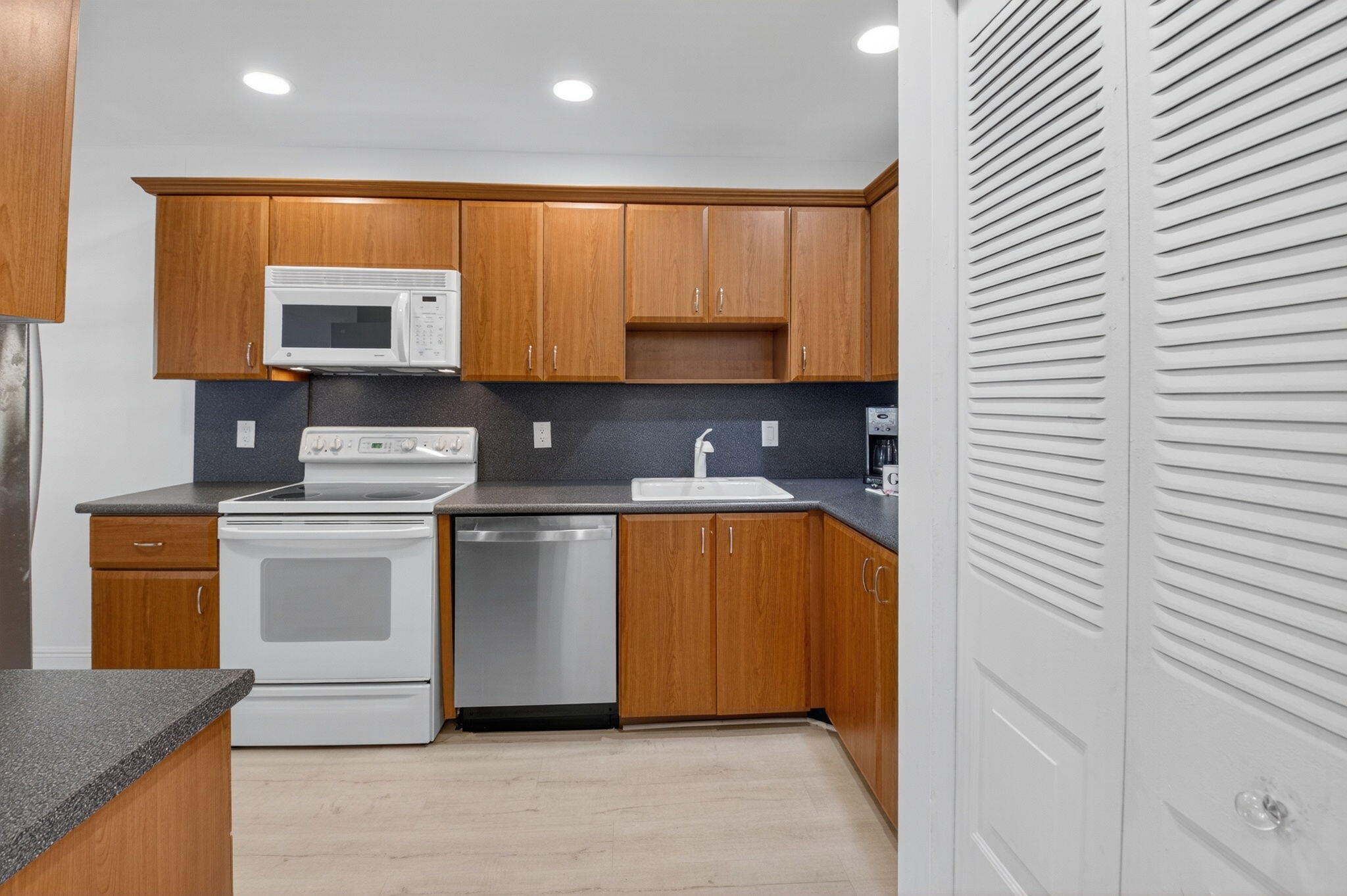 10 Southport Lane, Unit B Boynton Beach, FL 33436 - Photo 26 of 80 a kitchen with stainless steel appliances granite countertop a stove a sink and a microwave