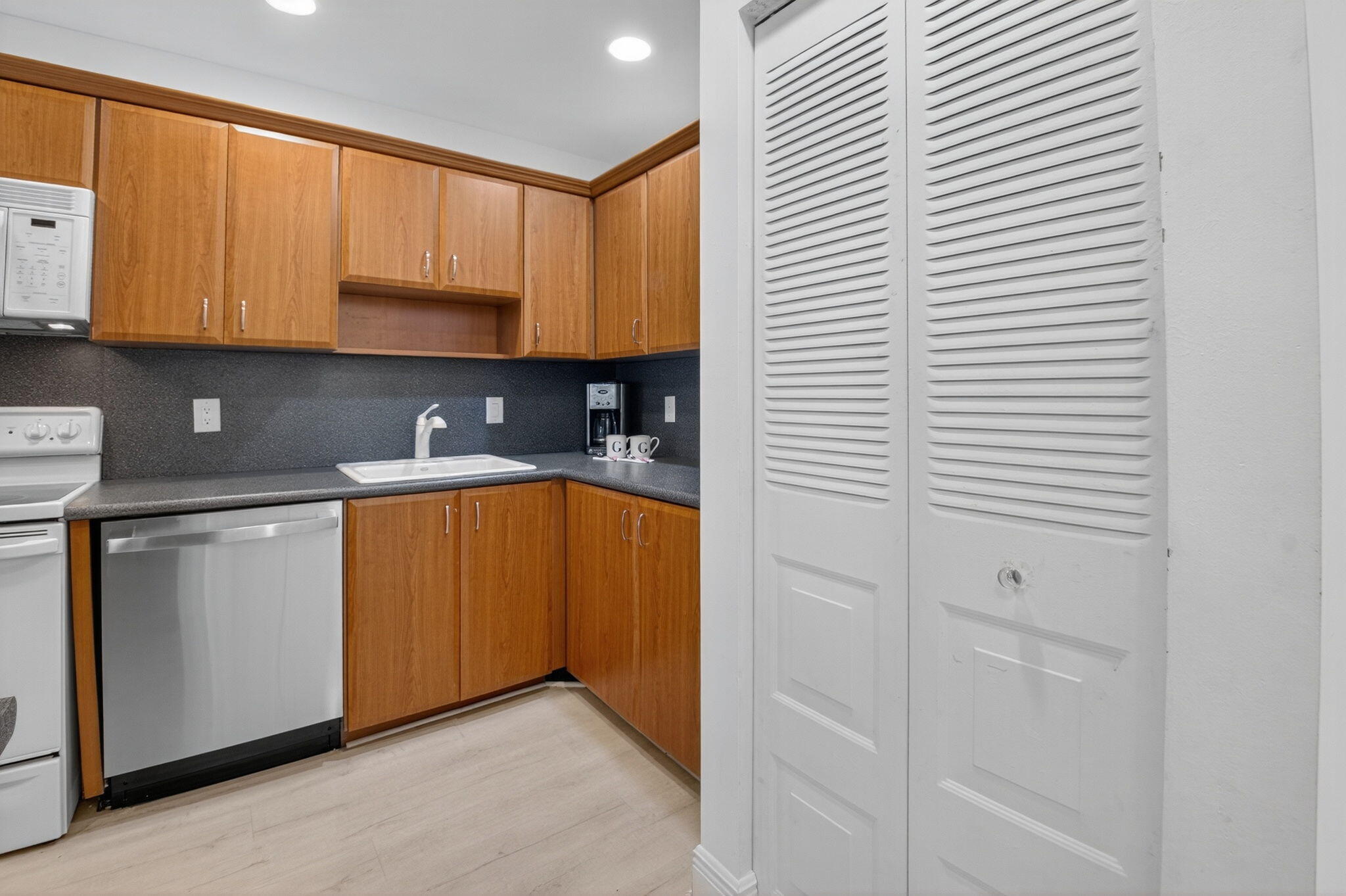 10 Southport Lane, Unit B Boynton Beach, FL 33436 - Photo 27 of 80 a kitchen with stainless steel appliances granite countertop a sink and a cabinets
