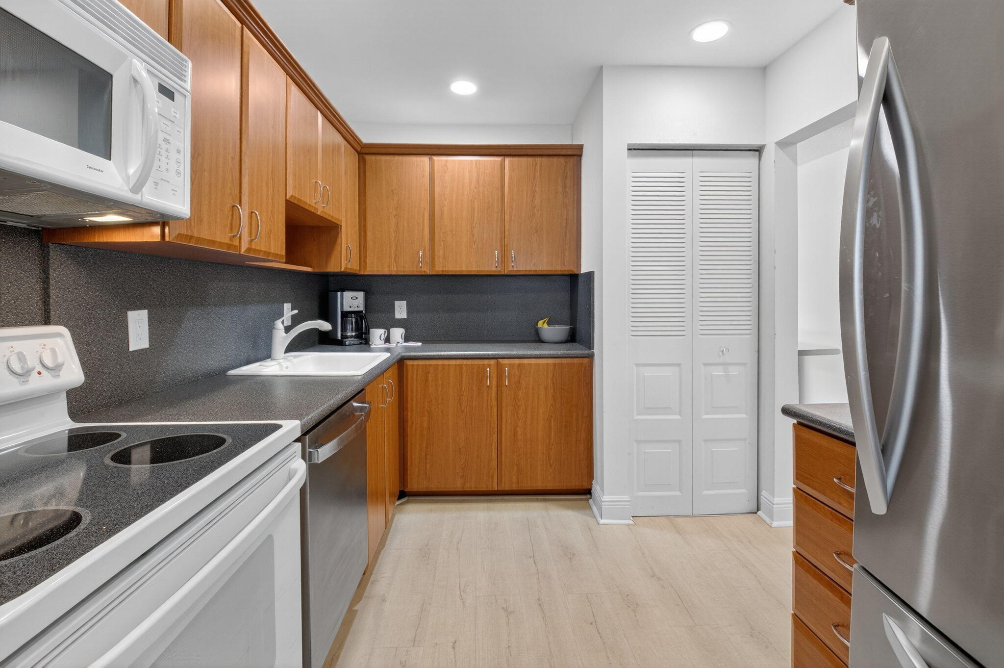 10 Southport Lane, Unit B Boynton Beach, FL 33436 - Photo 28 of 80 a kitchen with stainless steel appliances granite countertop a stove a sink and a refrigerator