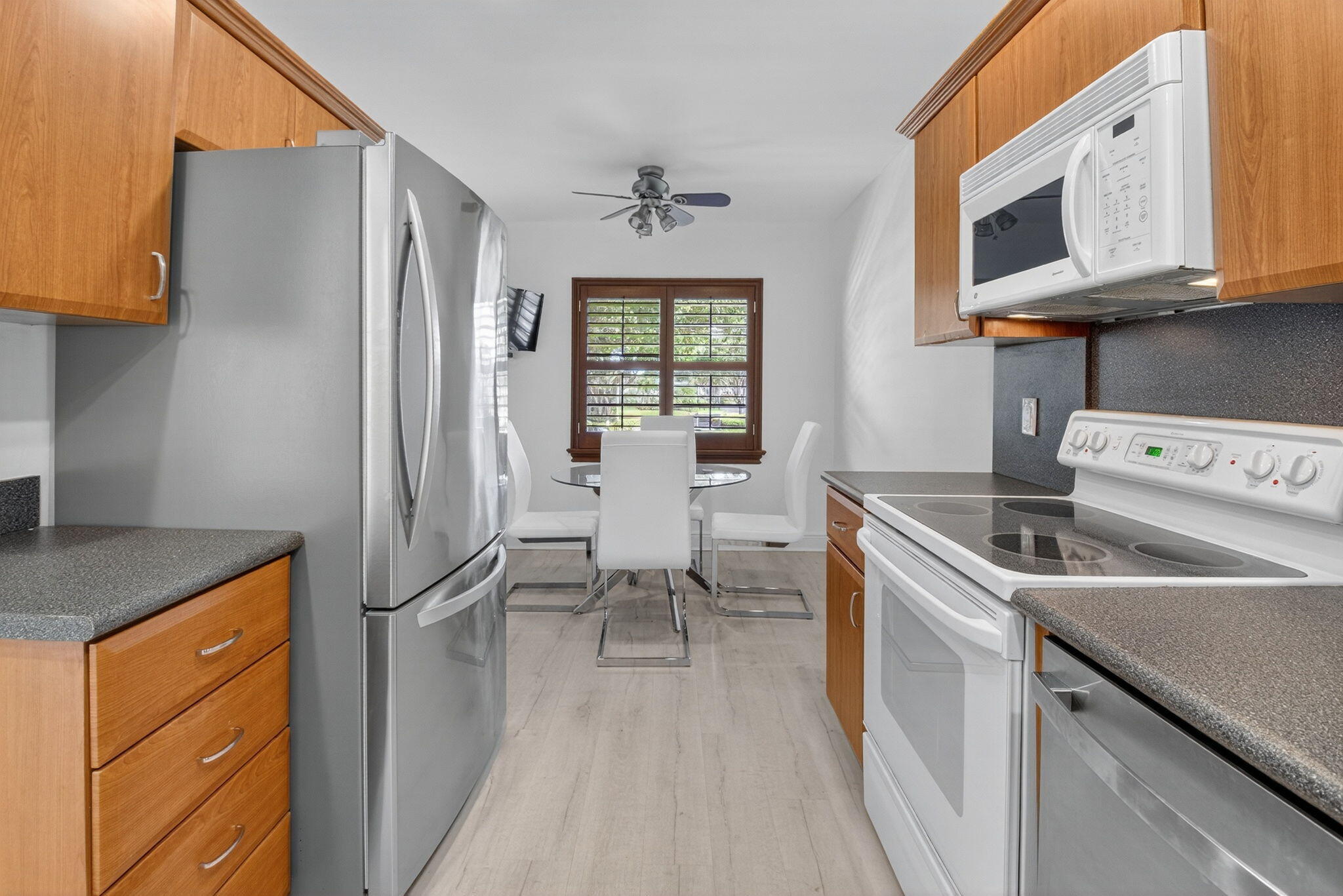 10 Southport Lane, Unit B Boynton Beach, FL 33436 - Photo 30 of 80 a kitchen with stainless steel appliances granite countertop a sink stove and refrigerator