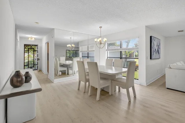 a view of a dining room with furniture a chandelier and wooden floor