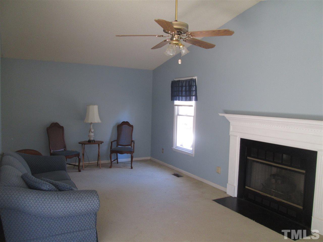 2600 Denbigh Court Raleigh, NC 27604 - Photo 4 of 13 a living room with furniture a chandelier and a fireplace