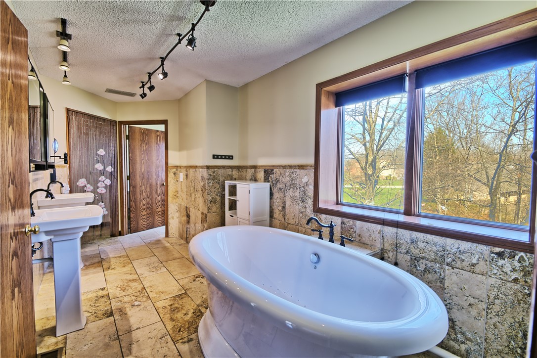 8711 Nicole Lane Springboro, OH 45066 - Photo 43 of 87 This tranquil bathroom features a freestanding tub and dual pedestal sinks, offering a serene escape.