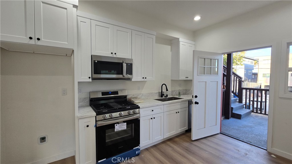 1040 Beacon Avenue, Unit 1040 Los Angeles, CA 90015 - Photo 4 of 8 a kitchen with a sink stove and cabinets