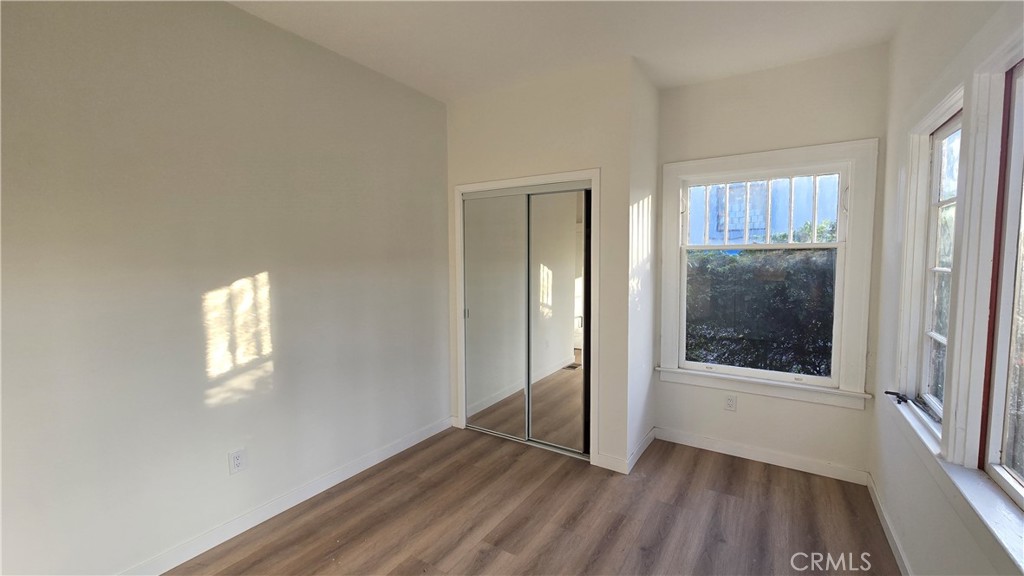 1040 Beacon Avenue, Unit 1040 Los Angeles, CA 90015 - Photo 5 of 8 an empty room with wooden floor and windows