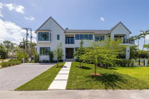 a front view of a house with a yard and potted plants