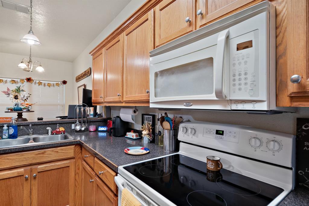 1155 Cage Street Stephenville, TX 76401 - Photo 29 of 38 a kitchen with stainless steel appliances granite countertop a sink stove and cabinets