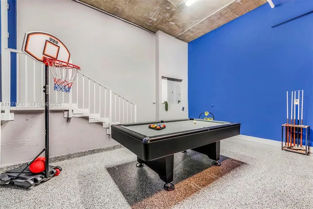 a room with pool table and windows