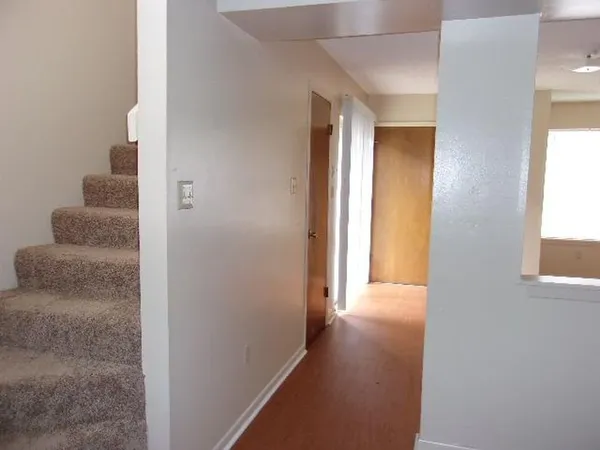 a view of a hallway with wooden floor and windows