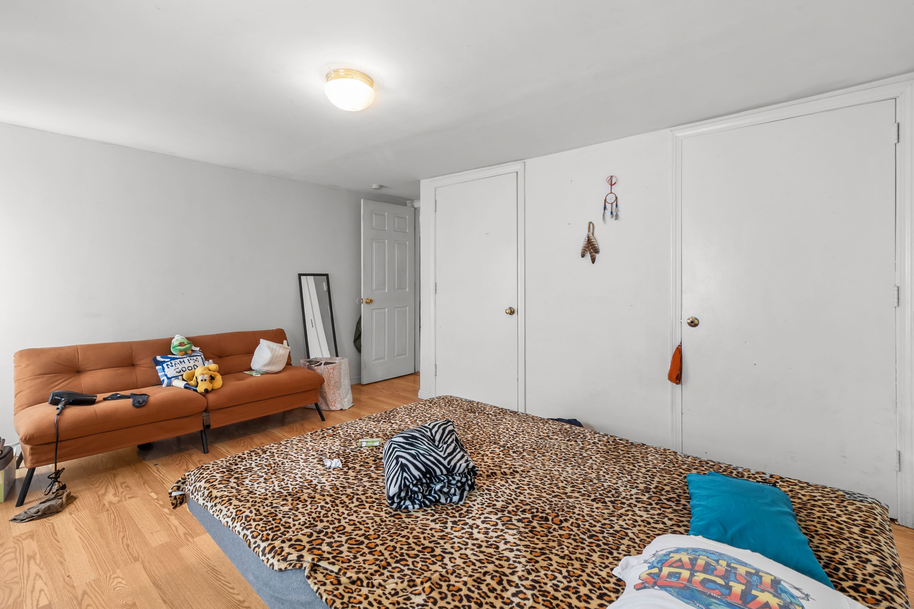 136 Washington Street Norwich, CT 06360 - Photo 36 of 40 a bedroom with a bed and wooden floor