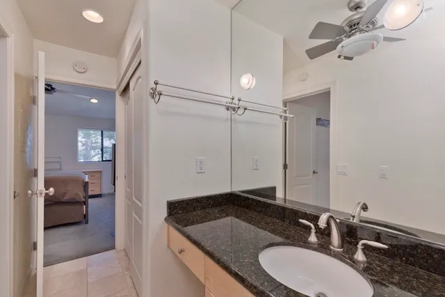 a bathroom with a granite countertop sink a mirror and shower