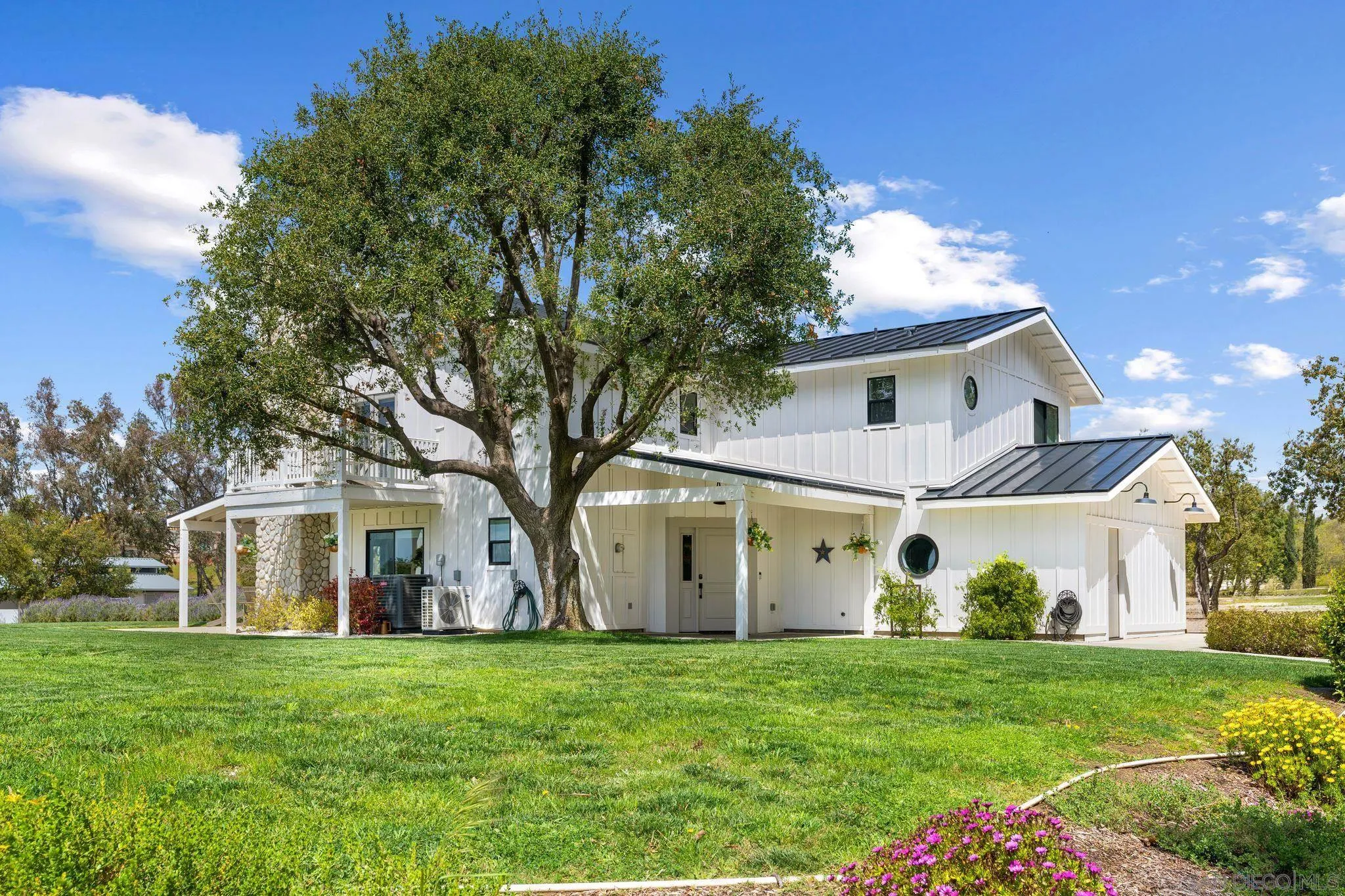 36260 Monte De Oro Road Temecula, CA 92592 - Photo 1 of 1 a view of a white house in front of a big yard with large trees