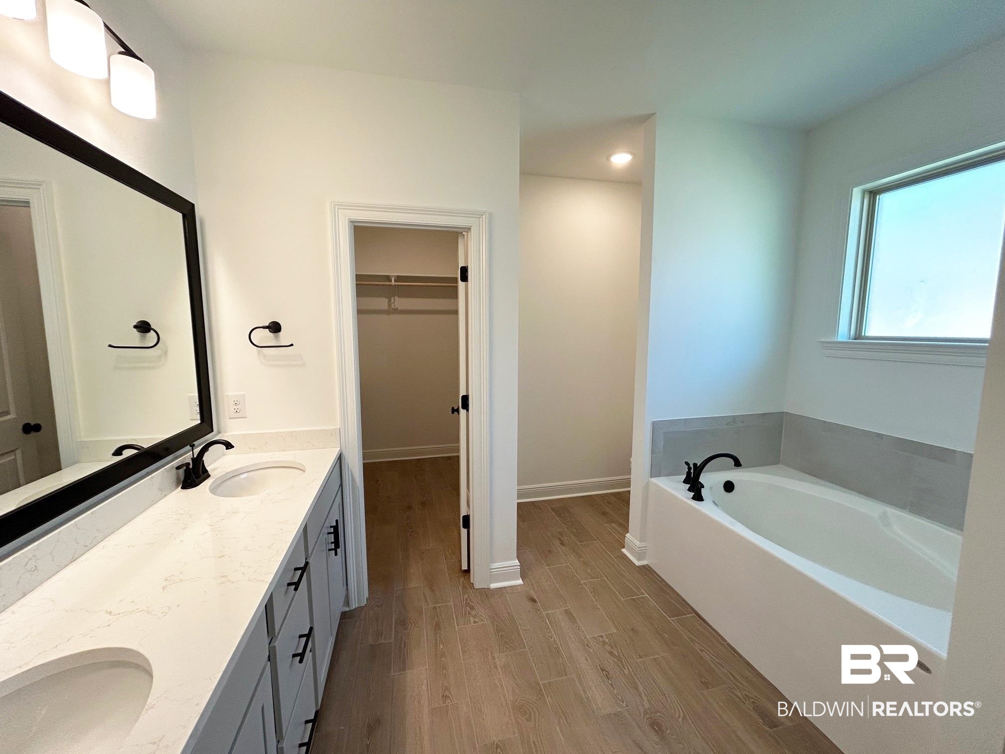 812 Sumter Loop Foley, AL 36535 - Photo 8 of 17 Bathroom with hardwood / wood-style flooring, vanity, and a washtub