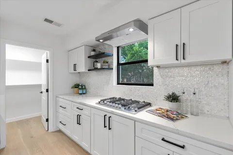 a kitchen with white cabinets and a stove