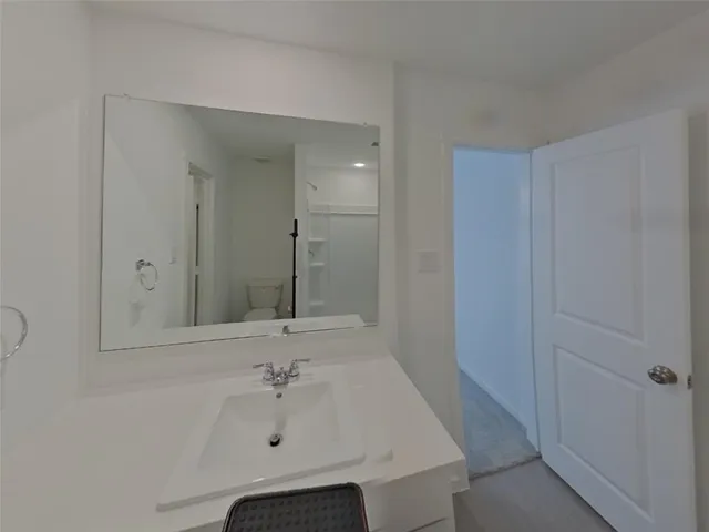 an empty room with a chandelier fan and windows