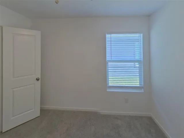 an empty room with a chandelier fan