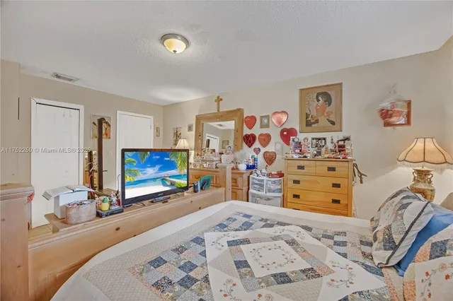 a bed room with a bed and a flat tv screen on dresser