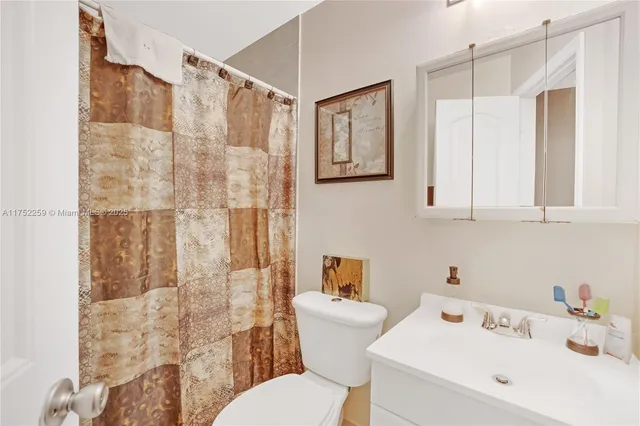 a bathroom with a sink a toilet and shower curtain