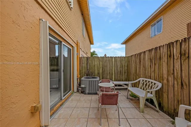 a backyard of a house with barbeque oven table and chairs