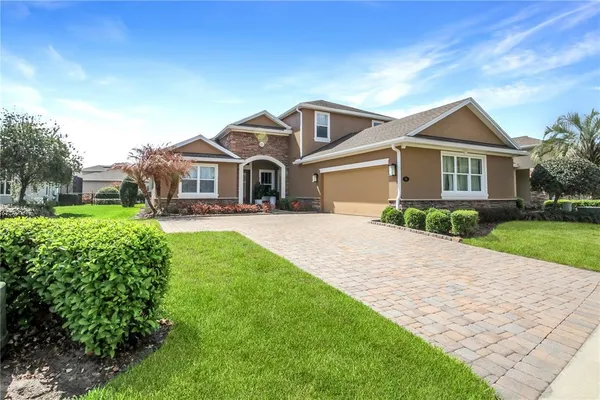 a front view of a house with a yard and potted plants