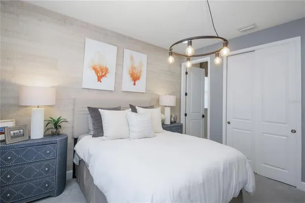 a bedroom with a bed and a chandelier