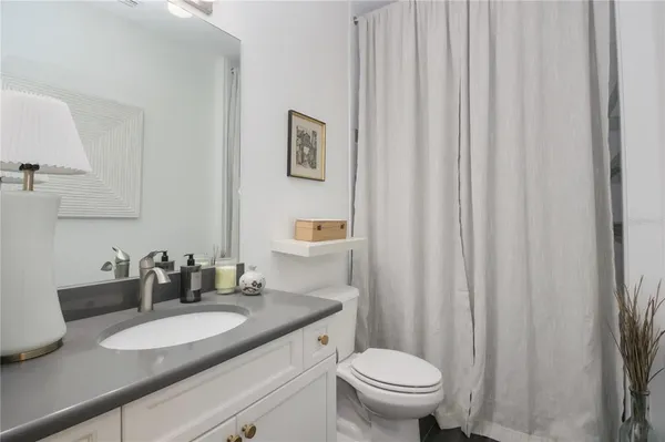 a bathroom with a granite countertop sink a mirror and a shower
