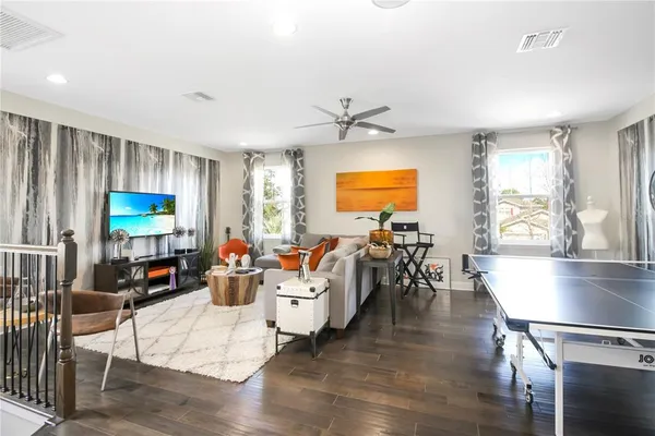 a living room with furniture and a wooden floor
