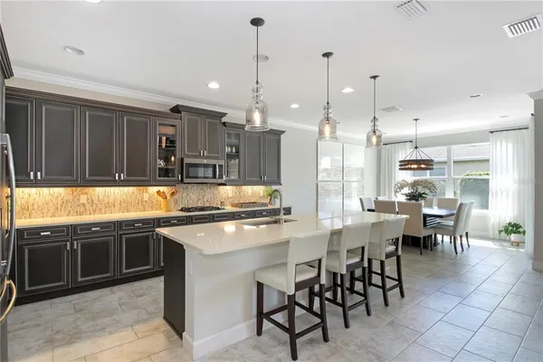 a kitchen with stainless steel appliances granite countertop table chairs sink and cabinets