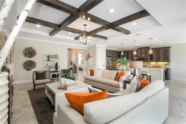 a living room with furniture kitchen view and a chandelier