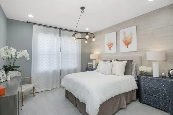 a bedroom with a large bed and a chandelier