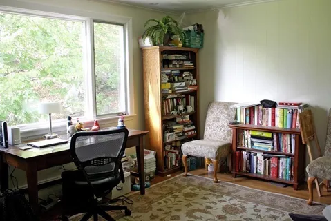 a living room with furniture and a book shelf