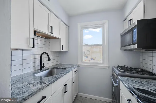 a kitchen with stainless steel appliances granite countertop a sink stove top oven and cabinets