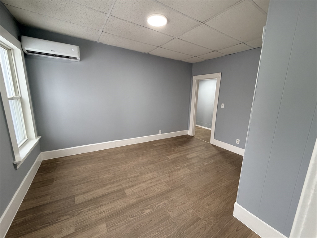 22 Knowlton Street, Unit 6 Gardner, MA 01440 - Photo 4 of 9 an empty room with wooden floor and windows