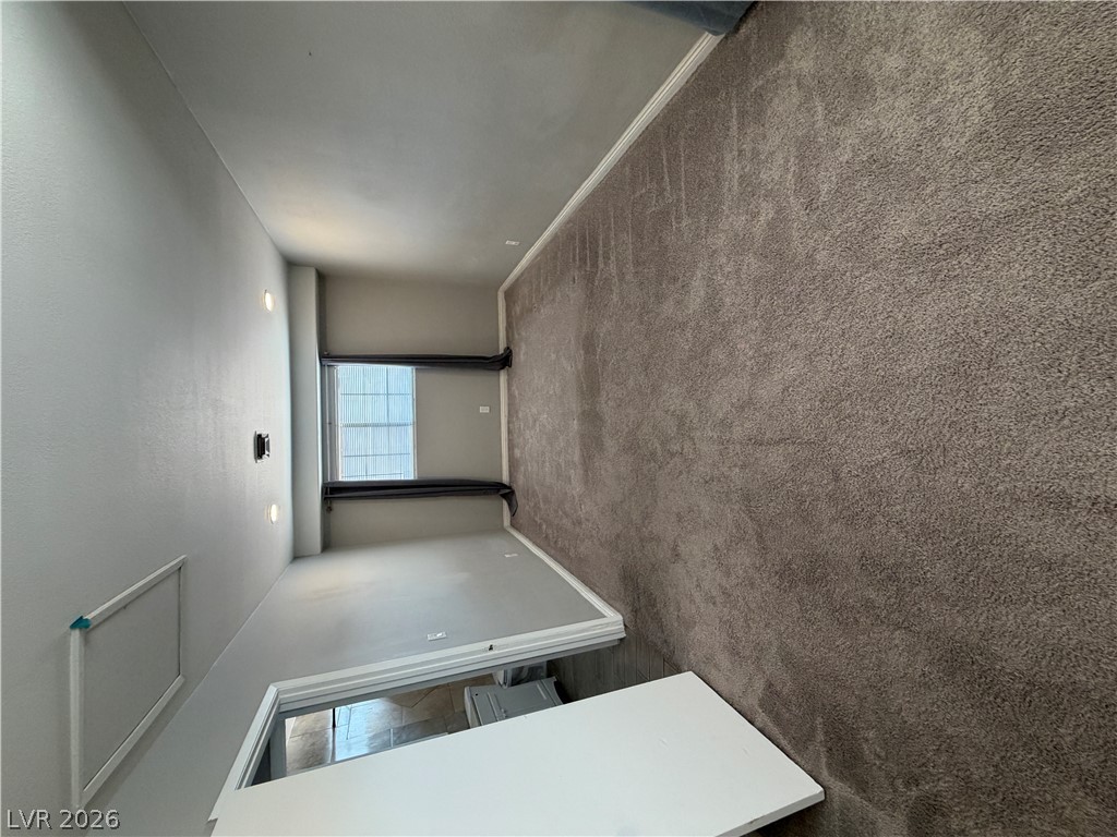 2820 South Sandhill Road, Unit A Las Vegas, NV 89121 - Photo 22 of 26 Plush carpeting creates a cozy atmosphere in this well-lit living area.