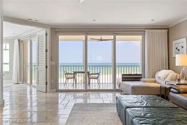 a living room with furniture and a floor to ceiling window