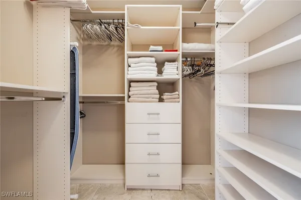 a view of walk in closet with clothes and shoes